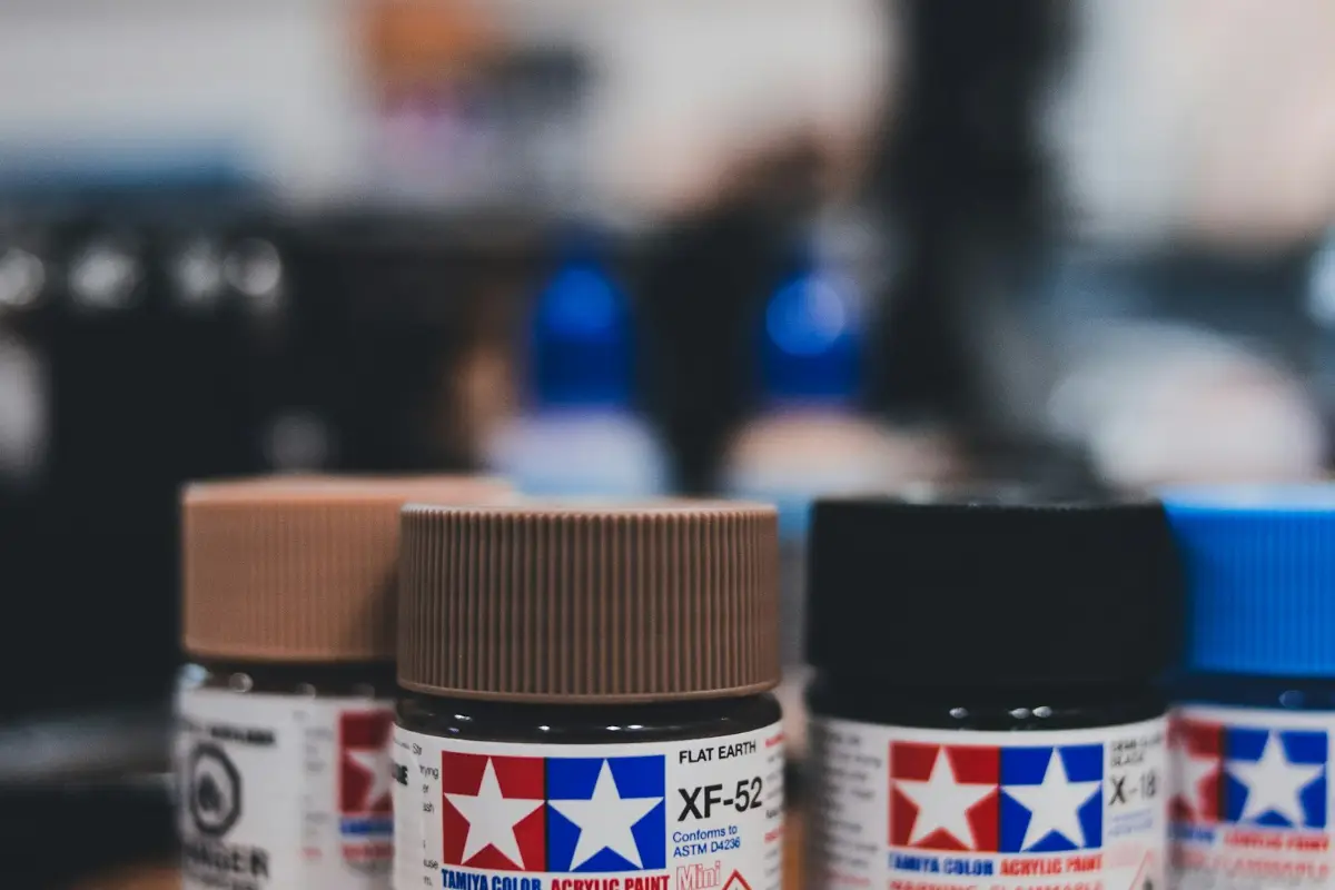 Three jars of acrylic paint on a wooden table